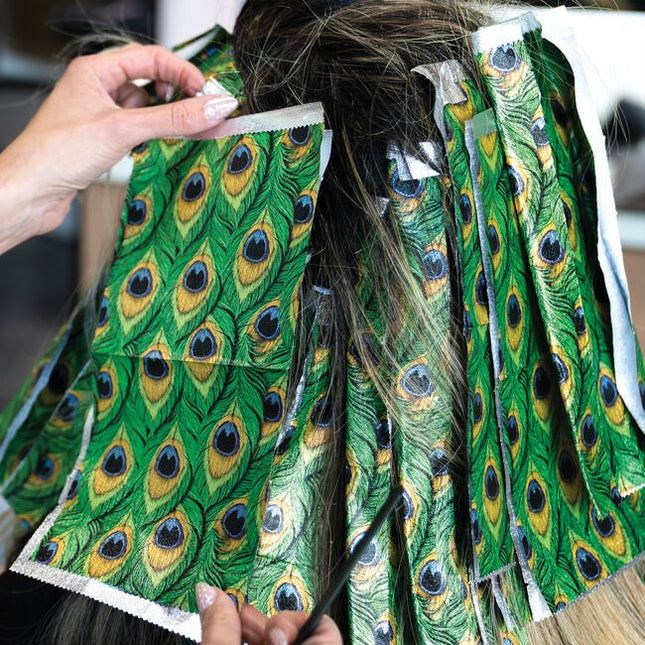 Step into the spotlight with Peacock, a foil made to show off. Inspired by the fiercest feathers in nature, this design brings rich jewel tones and graceful detail to every service. With flawless grip and smooth saturation, each sheet helps you create color that struts with confidence and shines with unapologetic glam. From brilliant blondes to dimensional brunettes, every highlight becomes a statement worth noticing. Bold, beautiful, and born to stand out, this is Peacock.