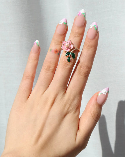 A touch of ooh la la. The Fleur de Magnolia press-ons bring effortless French charm to your fingertips! Inspired by the magnolia flower and the timeless elegance of a Parisian garden, these press-on nails combine soft pink bases with crisp white French tips, adorned with delicate floral accents and fresh green leaves. 