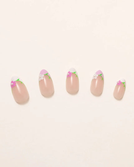 A touch of ooh la la. The Fleur de Magnolia press-ons bring effortless French charm to your fingertips! Inspired by the magnolia flower and the timeless elegance of a Parisian garden, these press-on nails combine soft pink bases with crisp white French tips, adorned with delicate floral accents and fresh green leaves. 