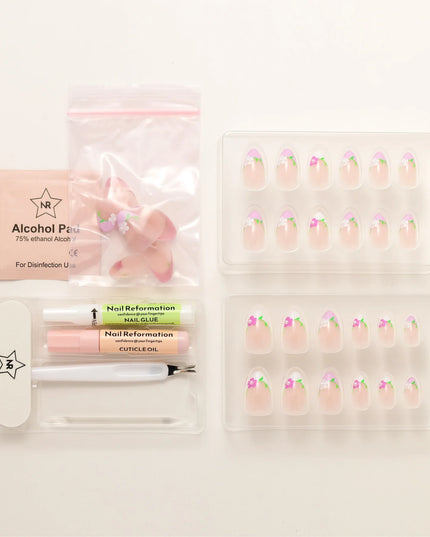 A touch of ooh la la. The Fleur de Magnolia press-ons bring effortless French charm to your fingertips! Inspired by the magnolia flower and the timeless elegance of a Parisian garden, these press-on nails combine soft pink bases with crisp white French tips, adorned with delicate floral accents and fresh green leaves. 