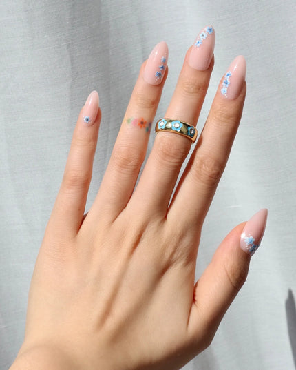 A little bloom goes a long way with Sprigs of Blue. These press-on nails embrace delicate floral accents without overwhelming your style. Soft blue petals scatter over a neutral base, creating a design that’s light, refined, and effortlessly elegant. The medium almond shape keeps things polished, while the glossy finish enhances the fresh, minimalist appeal. Whether you're elevating an everyday look or adding a subtle floral flourish, Sprigs of Blue is proof that simplicity blooms beautifully.