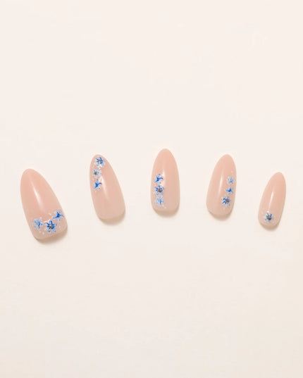 A little bloom goes a long way with Sprigs of Blue. These press-on nails embrace delicate floral accents without overwhelming your style. Soft blue petals scatter over a neutral base, creating a design that’s light, refined, and effortlessly elegant. The medium almond shape keeps things polished, while the glossy finish enhances the fresh, minimalist appeal. Whether you're elevating an everyday look or adding a subtle floral flourish, Sprigs of Blue is proof that simplicity blooms beautifully.