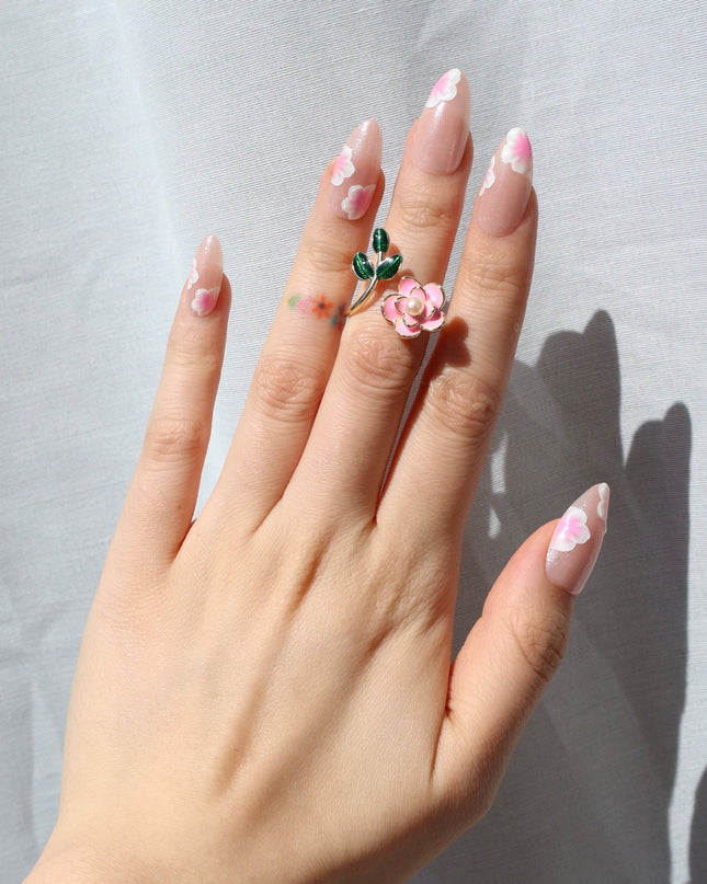 A glow that blooms all season. Sakura Glow press-on nails bring scattered cherry blossom petals with a glossy pink base that catches the light beautifully. The petals alternate across the tip and base, creating a design that feels like a gentle cascade of cherry blossoms in full bloom.
