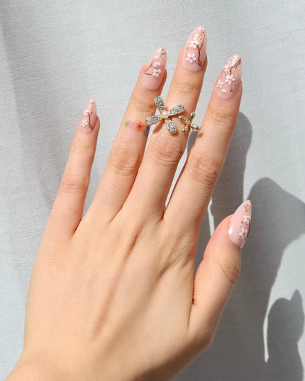 As effortless as cherry blossoms drifting in the wind. Soft Sakura press-ons embrace the beauty of simplicity with delicate floral accents on a soft nude base. Wispy branches stretch across each nail, adorned with hand-painted cherry blossoms and subtle gold flecks for a natural glow.