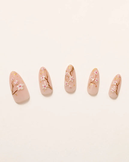 As effortless as cherry blossoms drifting in the wind. Soft Sakura press-ons embrace the beauty of simplicity with delicate floral accents on a soft nude base. Wispy branches stretch across each nail, adorned with hand-painted cherry blossoms and subtle gold flecks for a natural glow.