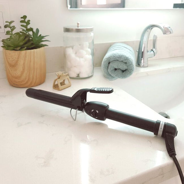 Achieve stunning, quality curls with the StyleCraft Black Gold Curling Iron.The ceramic barrel is coated emitting negative ions that seal the hair cuticles to significantly reduce frizz and enhance shine. 